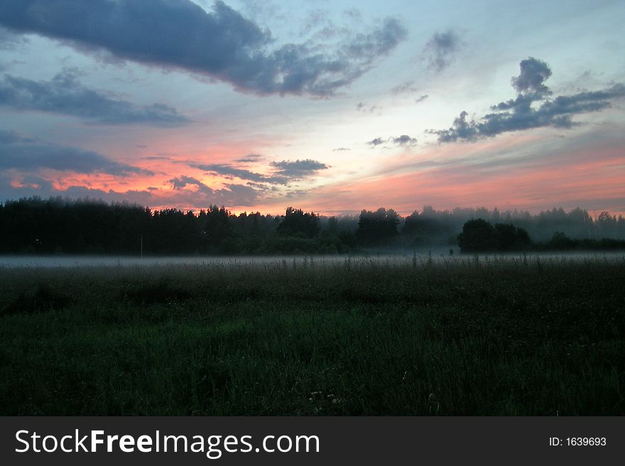 Misty sunset in the Russian country near the forest.