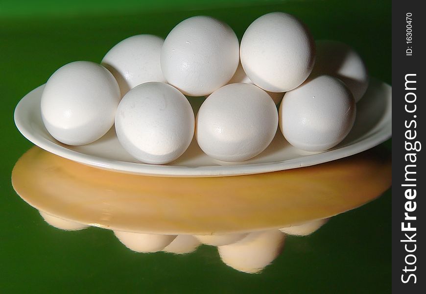 Dish of eggs on a white platter on a reflective base