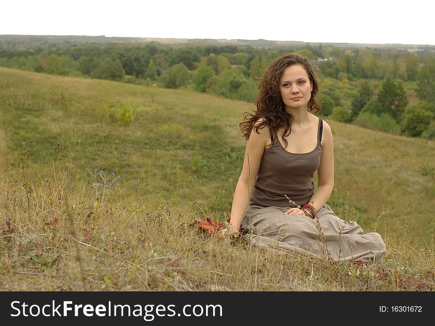 Female sitting in the autumn field