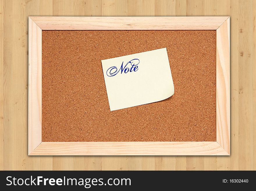 Corkboard with empty yellow notes on maple wood background