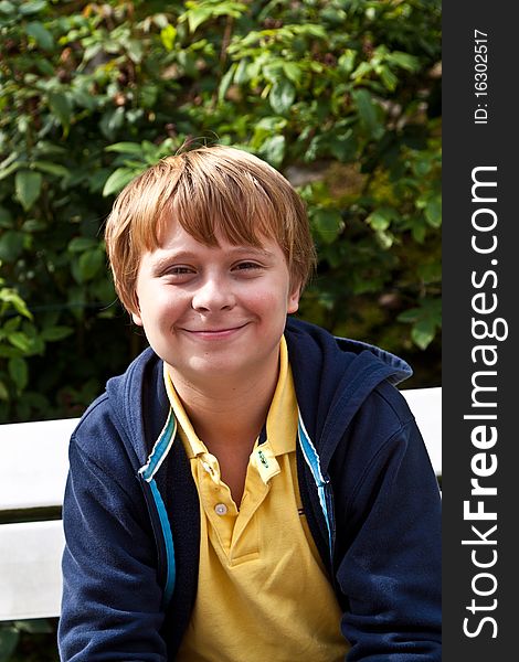 Boy sitting on a bench in a park