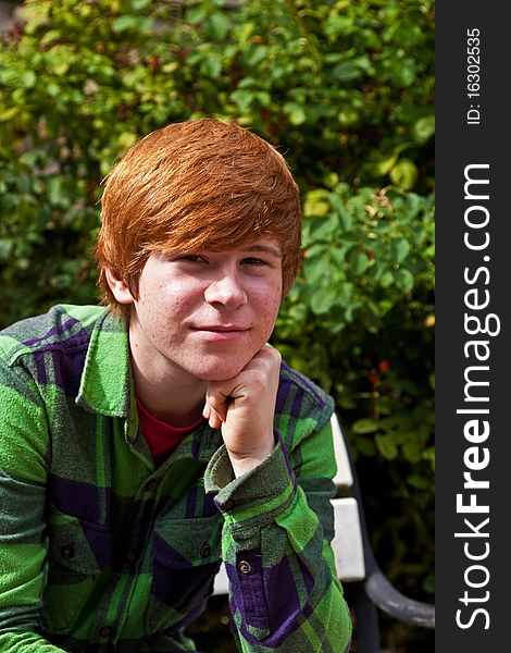 Boy sitting on a bench in a park