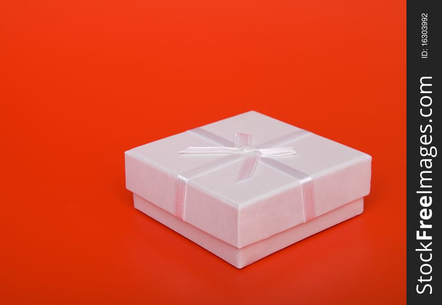 Gift box with ribbons, on  red background