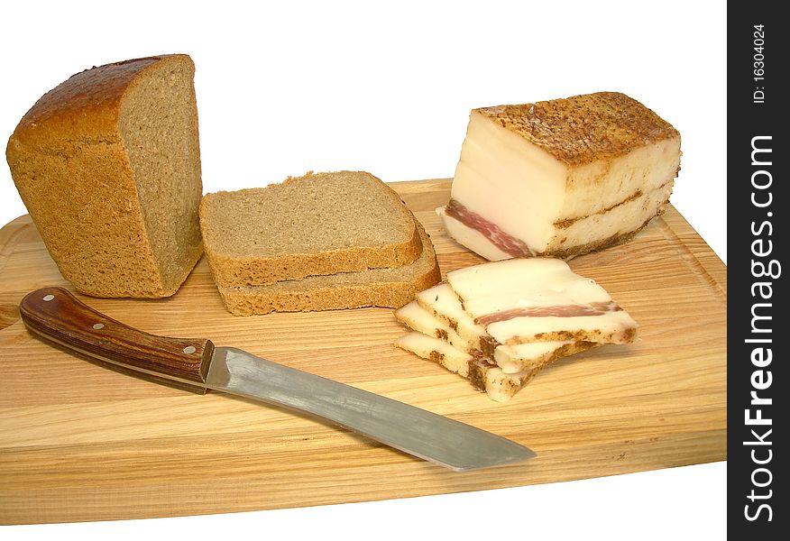 Bread and bacon are on a cutting board.