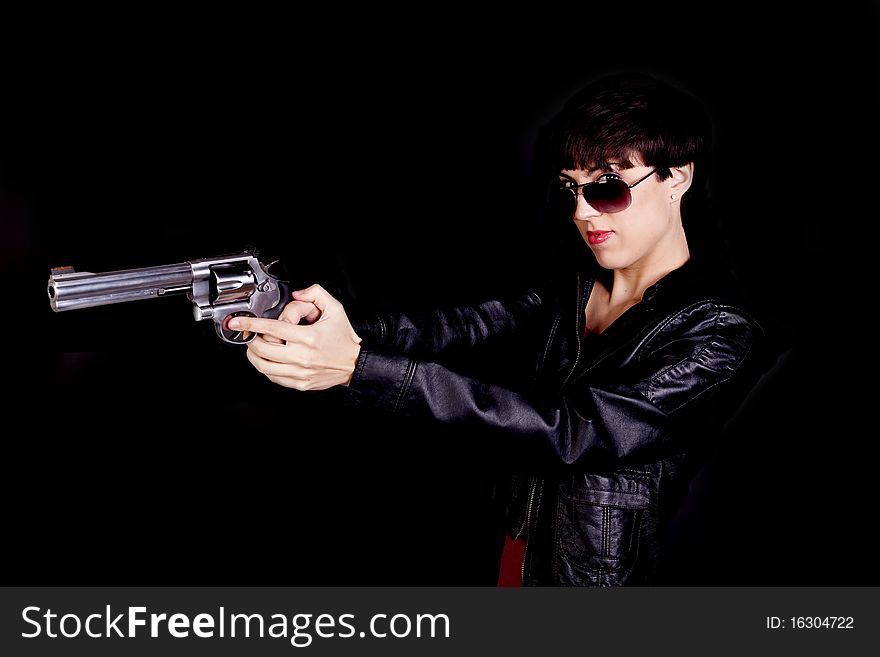 A woman wearing sunglasses pointing the gun away from the camera. A woman wearing sunglasses pointing the gun away from the camera.