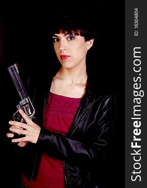 A woman holding a gun with a serious expression on her face. A woman holding a gun with a serious expression on her face.