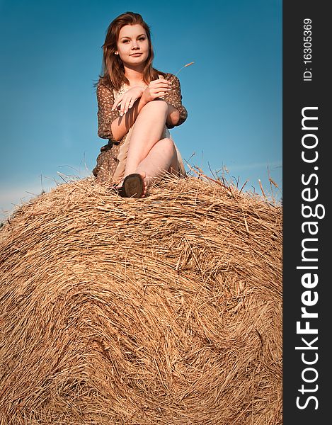 Young girl sitting on the field stack. Young girl sitting on the field stack