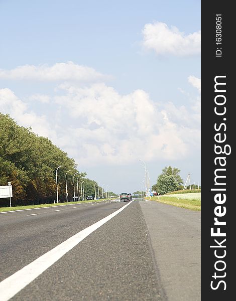 Highway with a road marking and cars which go in the afternoon