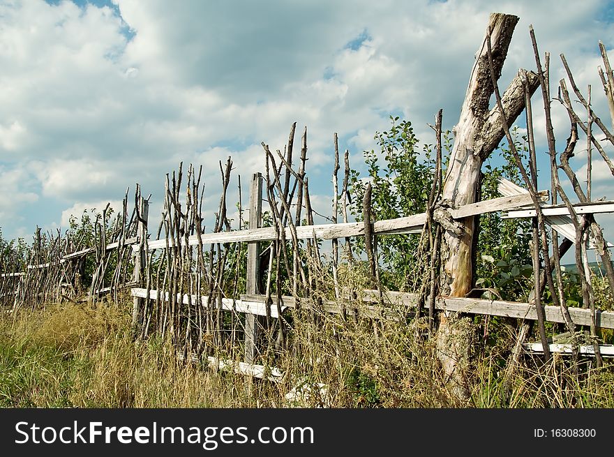 Old wooden fence in the village in summer