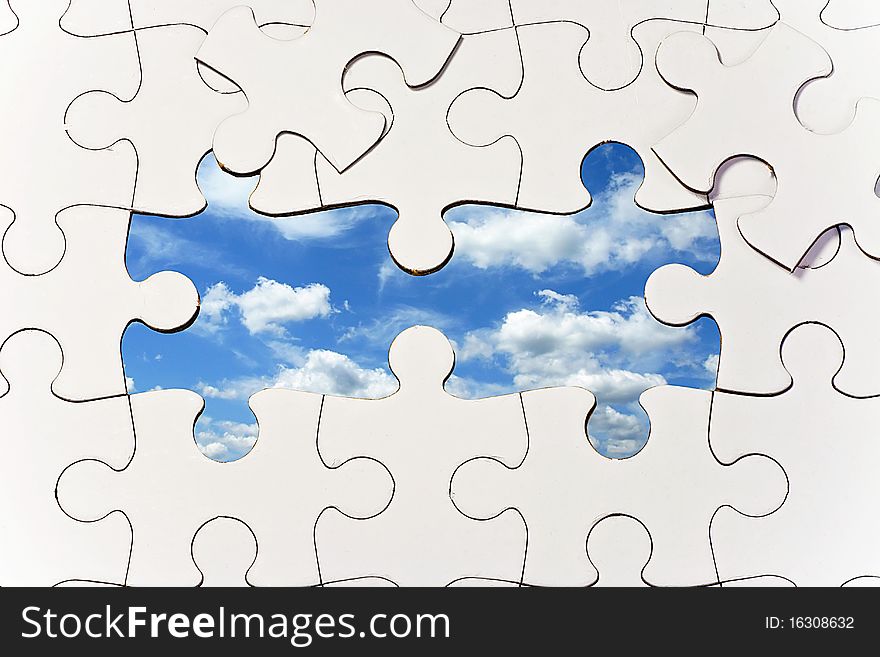 Puzzle background with missing pieces to reveal blue sky with clouds. Puzzle background with missing pieces to reveal blue sky with clouds.