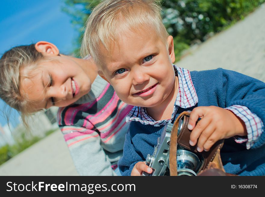 Pretty nice brother and sister playing with a camera on the street. Pretty nice brother and sister playing with a camera on the street