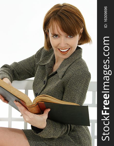 Beautiful 30 year old red head woman in suit with book over white. . Beautiful 30 year old red head woman in suit with book over white.