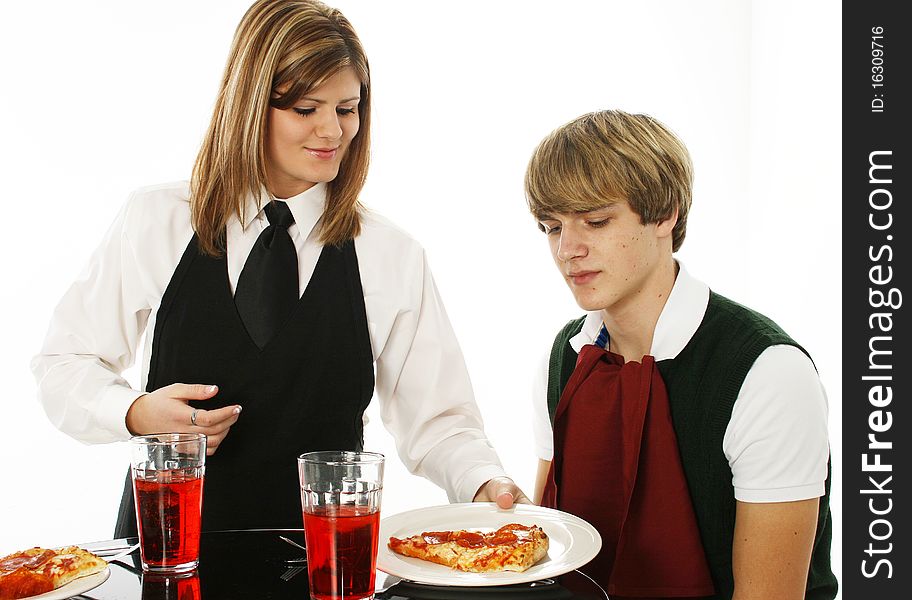 Teen in restaurant getting pizza from waitress over white background. Teen in restaurant getting pizza from waitress over white background.