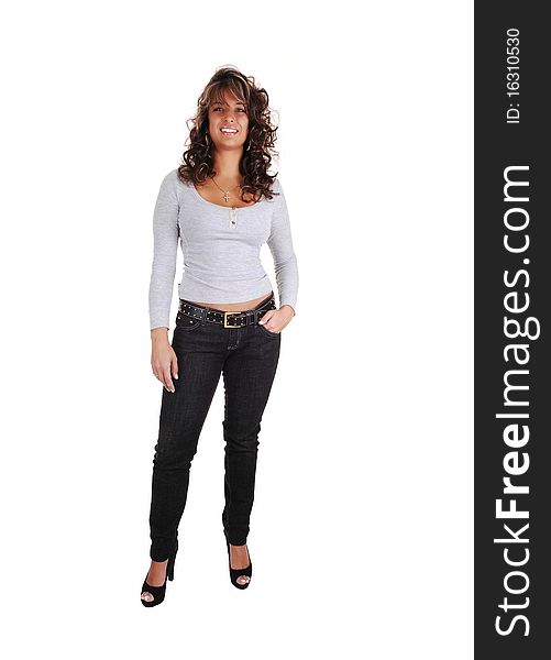 An pretty brunet woman in jeans and a gray sweater with long sleeves and high heels standing in the studio, for white background. An pretty brunet woman in jeans and a gray sweater with long sleeves and high heels standing in the studio, for white background.