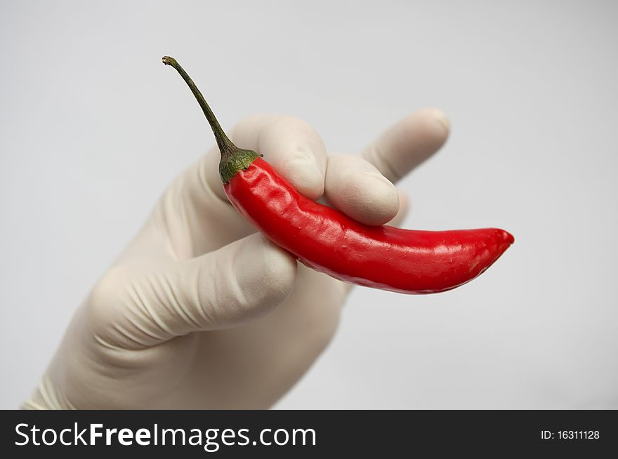 Hand with red pepper against to white background