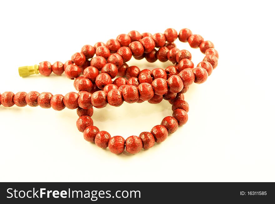 Wooden red necklace on a white background