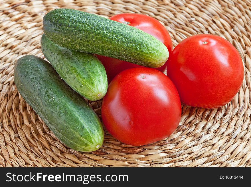 Still-life of Tomatoes and Cucumbers on a wicker background