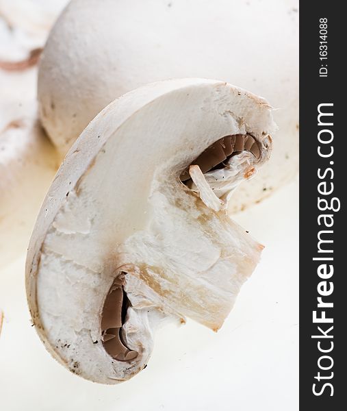 Champignons and a cut one on a white background