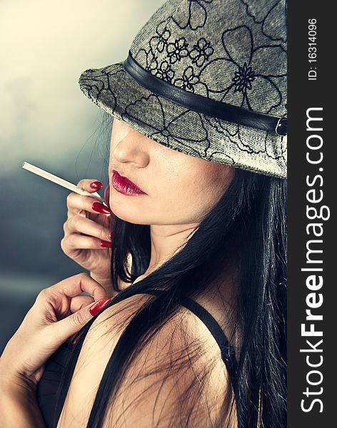 Beautiful smoking woman wearing hat