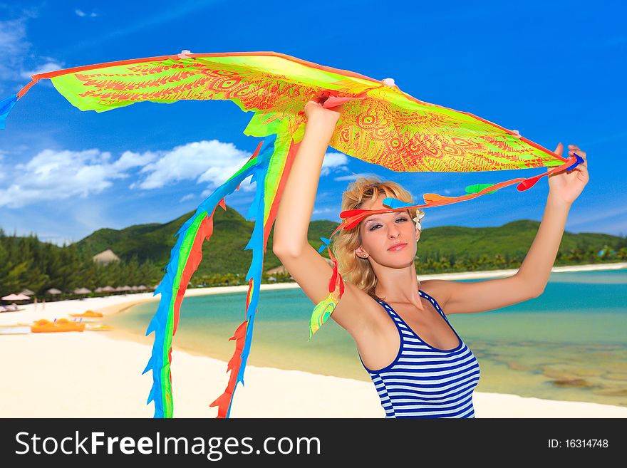 Young woman with kite on the beach