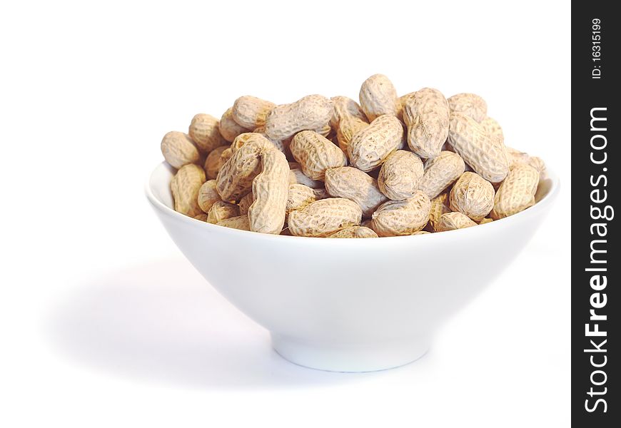 White bowl with unshelled peanuts, isolated on white.