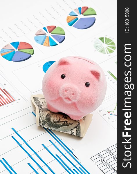 Piggy bank on money with business charts. Piggy bank on money with business charts