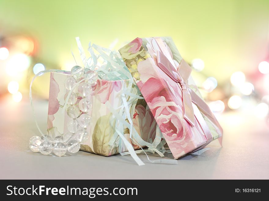 Gift box with beads and light dots background