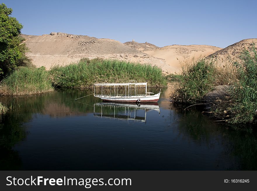 An Egyptian fisherman's boat on a blue lake in the dessert. An Egyptian fisherman's boat on a blue lake in the dessert