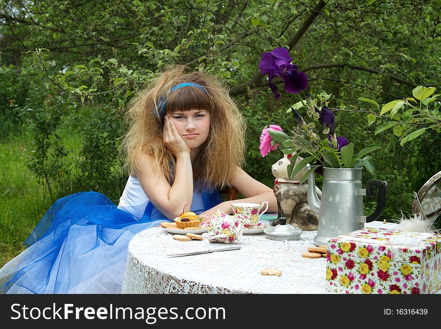 Beautiful girl with crazy hairstyle sitting near celebration table