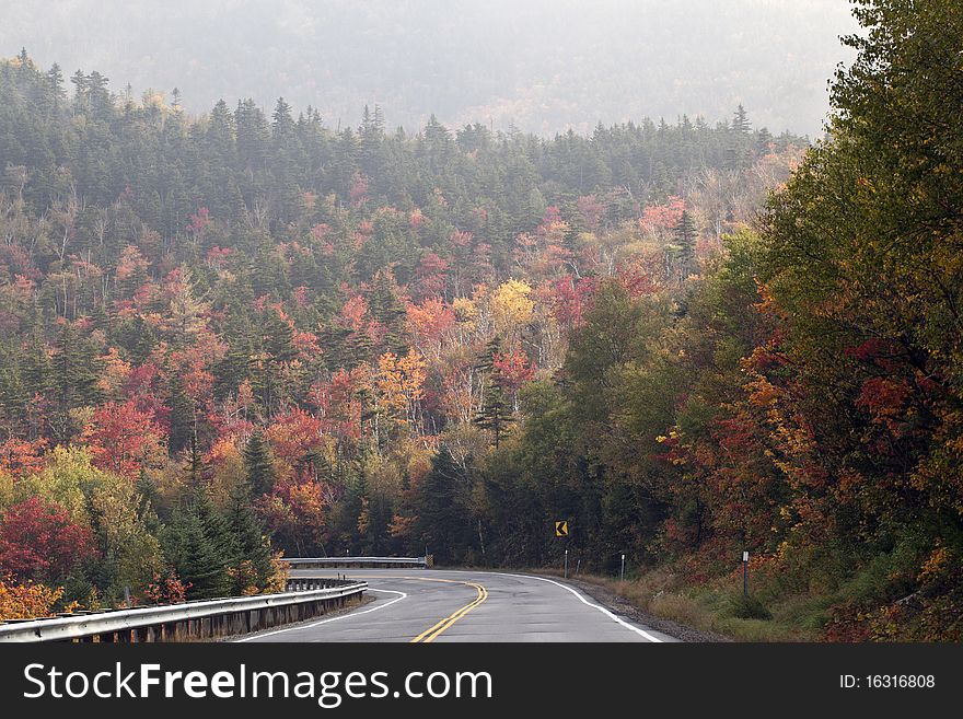 White mountains of New Hampshire down the highway in early autumn.Kancamagus Highway. White mountains of New Hampshire down the highway in early autumn.Kancamagus Highway