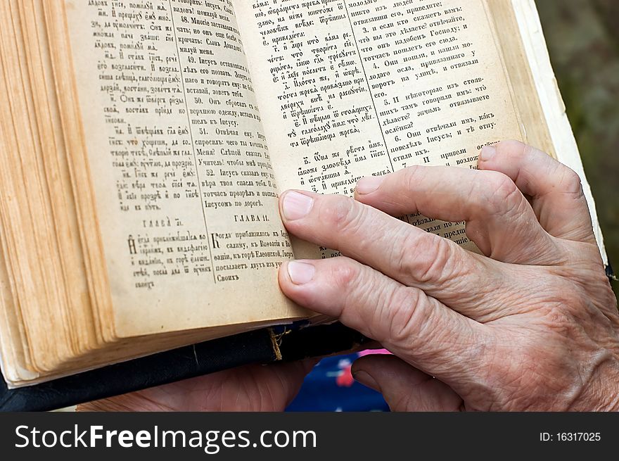 The old woman reads the bible close up