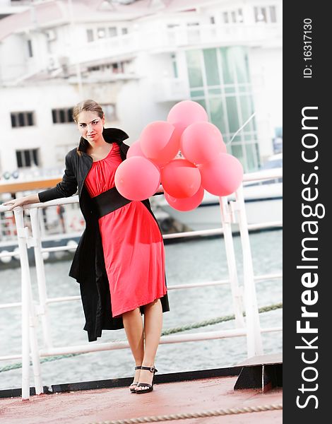 Attractive young woman with red balloons on urban background. Attractive young woman with red balloons on urban background