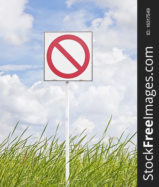 Sign warning on grass and sky background