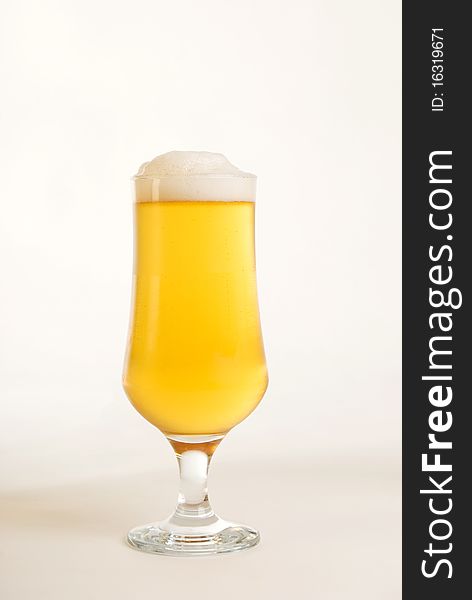 A vertical image of a glass of ice gold beer against a white background. A vertical image of a glass of ice gold beer against a white background