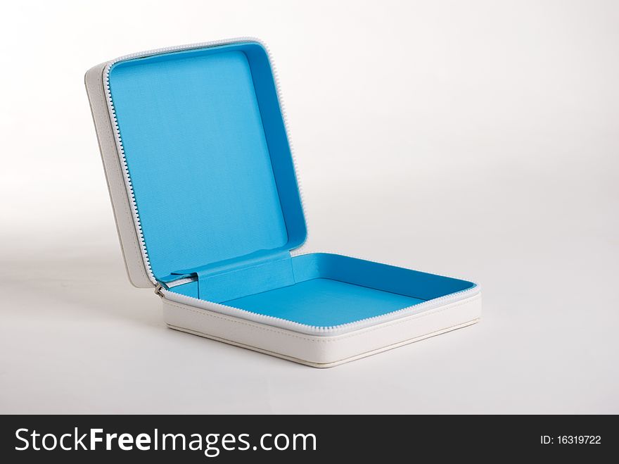 A horizontal image of a white leather zip case for makeup