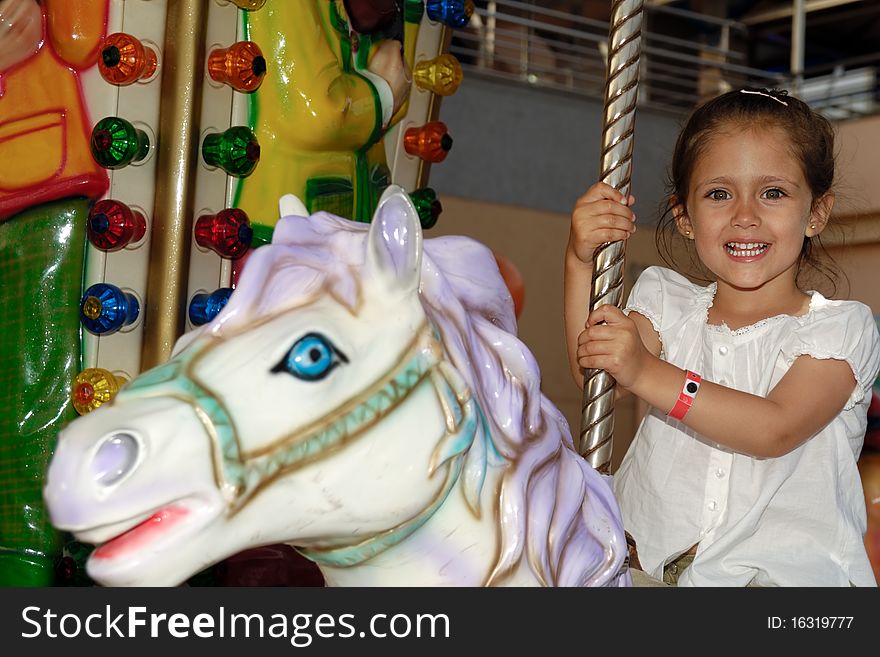 Child smiling sitting in a carousel