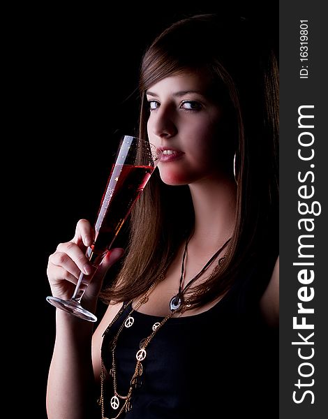 Young teenage party girl with a red drink. Isolated over black background. Young teenage party girl with a red drink. Isolated over black background.