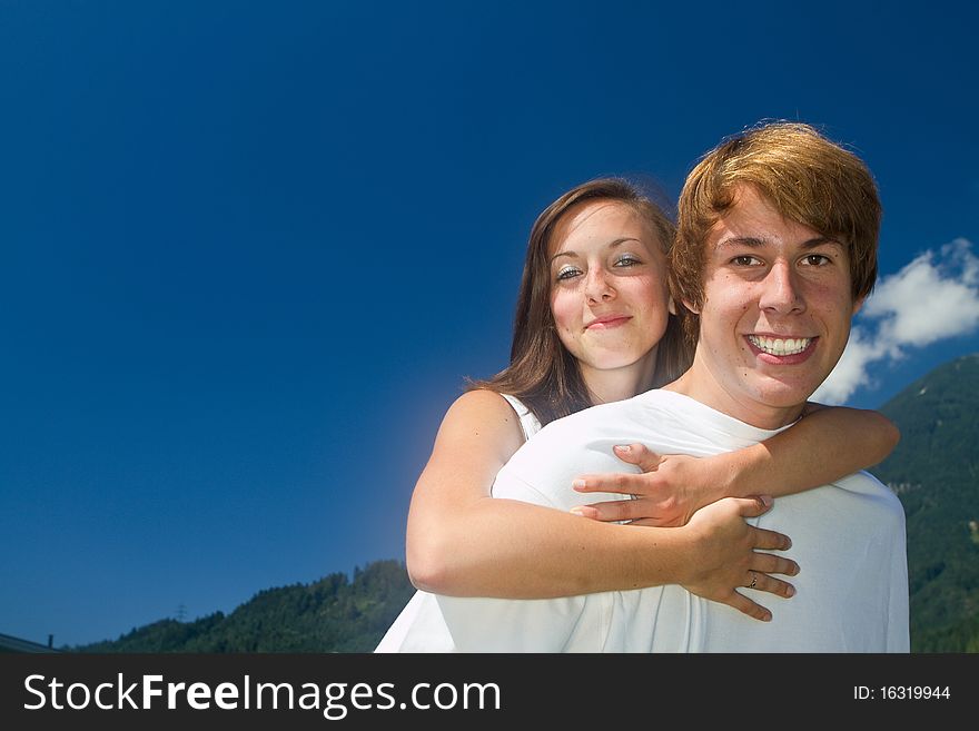 Young teenagers in love in a nature setting with blue skies. Young teenagers in love in a nature setting with blue skies.