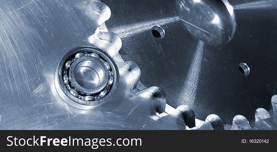 Industrial ball-bearings and cogs against aluminum background, blue toning idea, panoramic view. Industrial ball-bearings and cogs against aluminum background, blue toning idea, panoramic view
