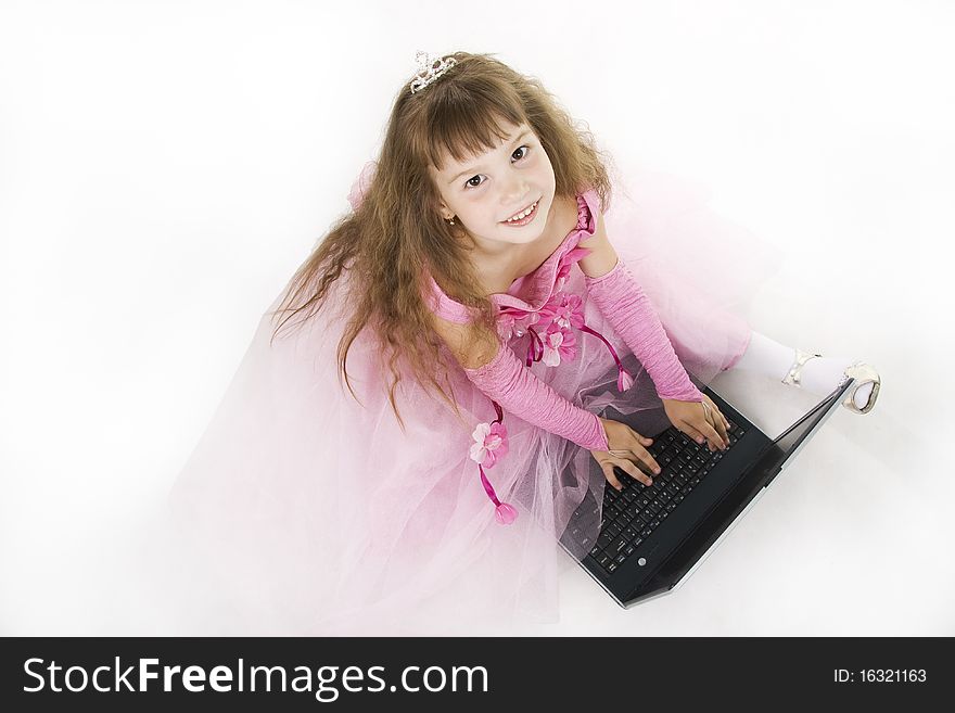 Little girl the princess plays with the notebook. White background. Little girl the princess plays with the notebook. White background