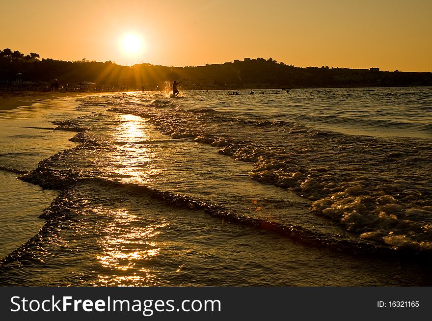 Sunset at the sea with waves in the front. Sunset at the sea with waves in the front