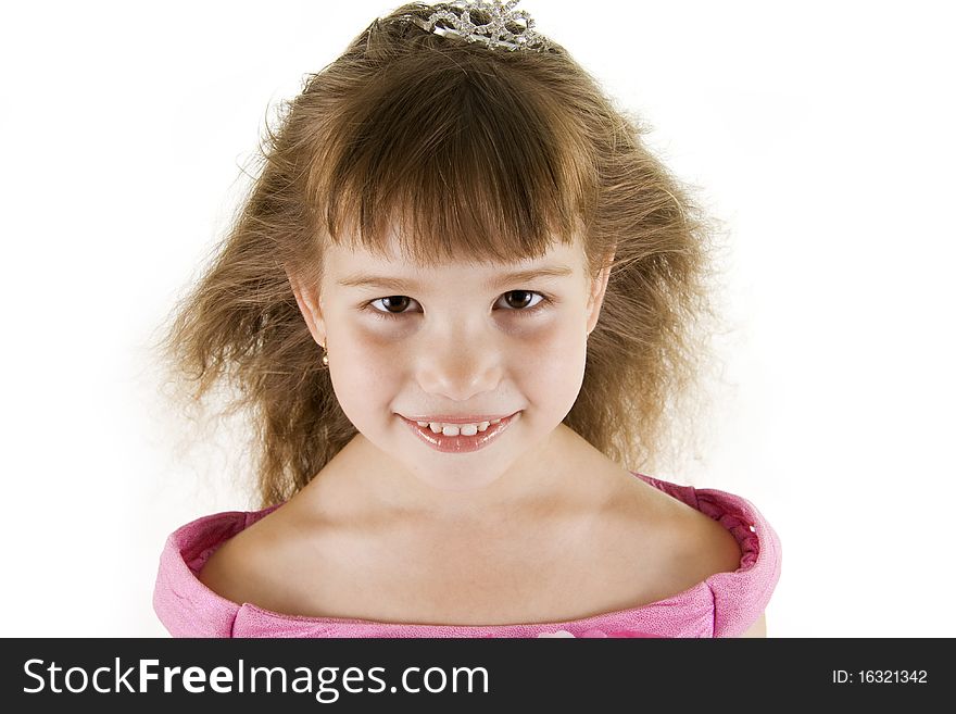 The girl the princess in a pink dress sits opposite to a white background. The girl the princess in a pink dress sits opposite to a white background