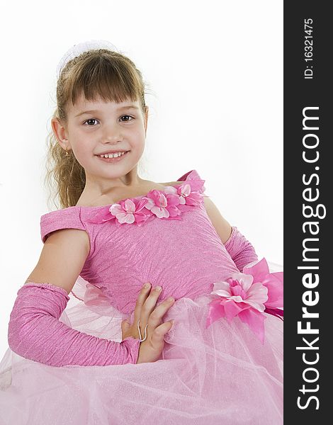 The girl the princess in a pink dress sits opposite to a white background. The girl the princess in a pink dress sits opposite to a white background