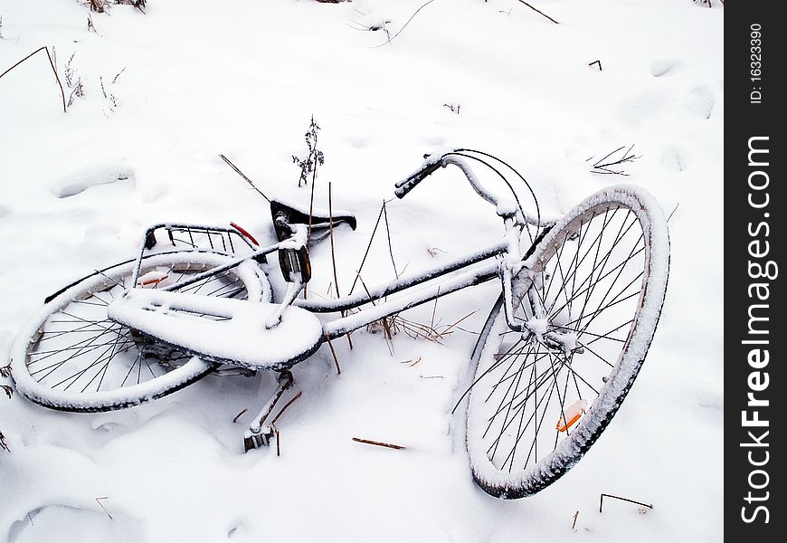 Bicycles covered with snow lay on the ground. Bicycles covered with snow lay on the ground