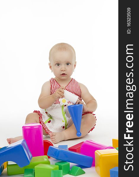 Dinky little girl plaies with plastic cubes, on white background. Dinky little girl plaies with plastic cubes, on white background.
