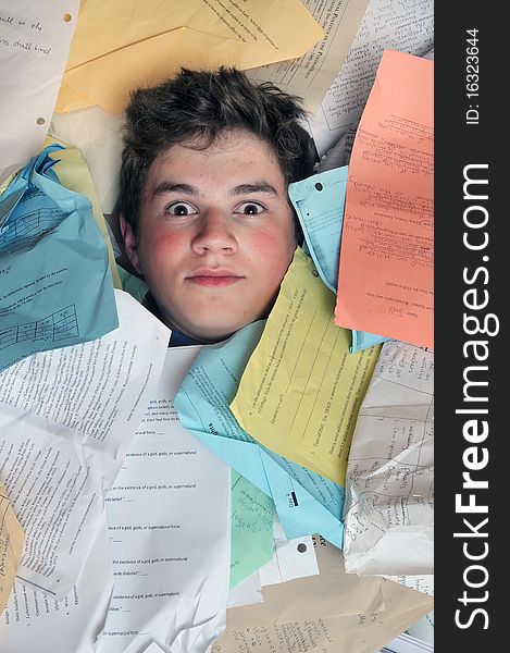 Young male student is overwhelmed by way too many homework assignments. Young male student is overwhelmed by way too many homework assignments.