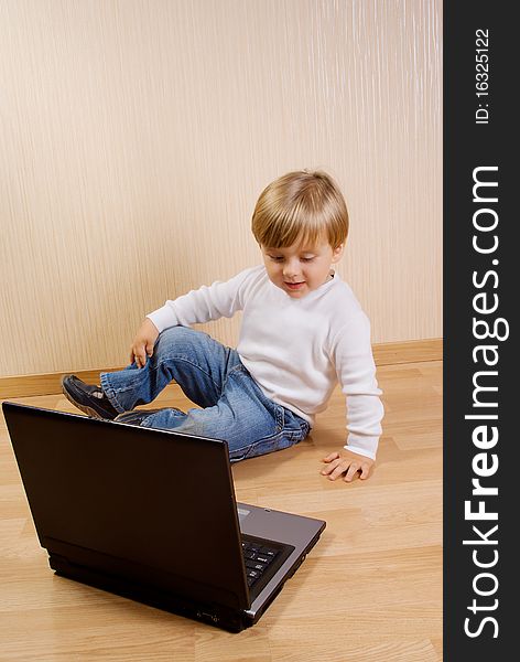 The child on the floor with laptop. The child on the floor with laptop