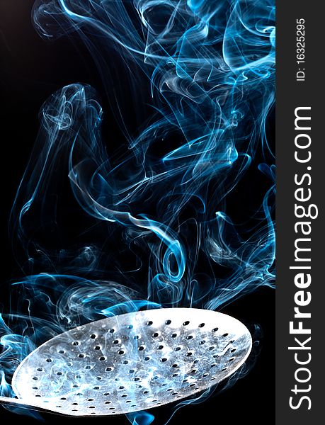 Smoke and spoon, isolated on a black background