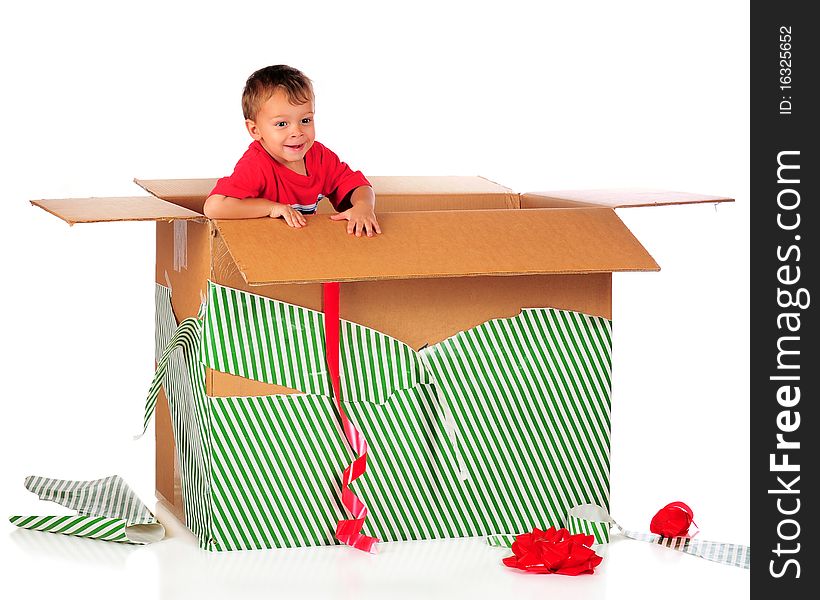 A happy preschooler playing in a giant-sized boy with the left-over wrappings from Chistmas. Isolated on white. A happy preschooler playing in a giant-sized boy with the left-over wrappings from Chistmas. Isolated on white.