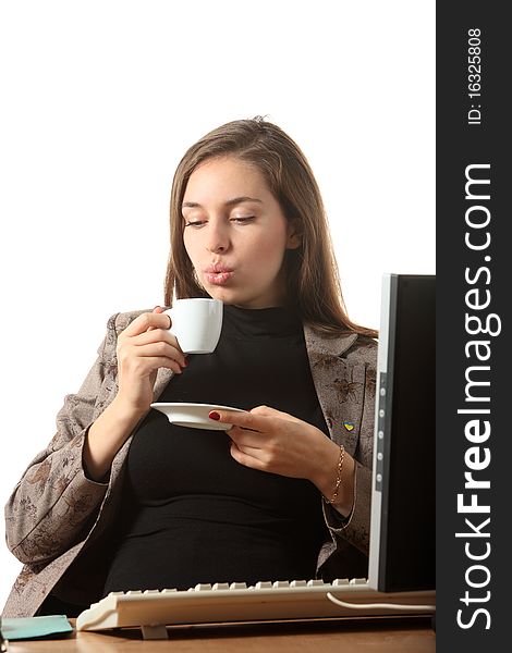 A businesswoman sit on her workspace and blow on a cup of coffee. A businesswoman sit on her workspace and blow on a cup of coffee